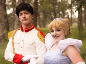Prince Charming lending an arm to the Cinder Princess to walk in her royal princess shoes at parties in Calgary
