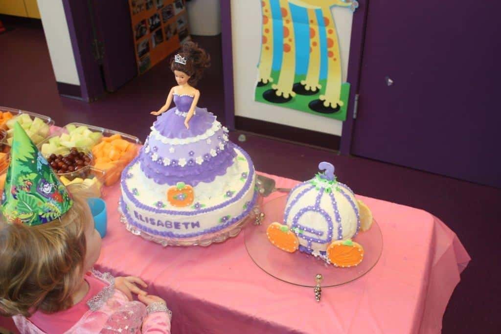 Princess birthday guest admiring masterpiece princess cake and carriage