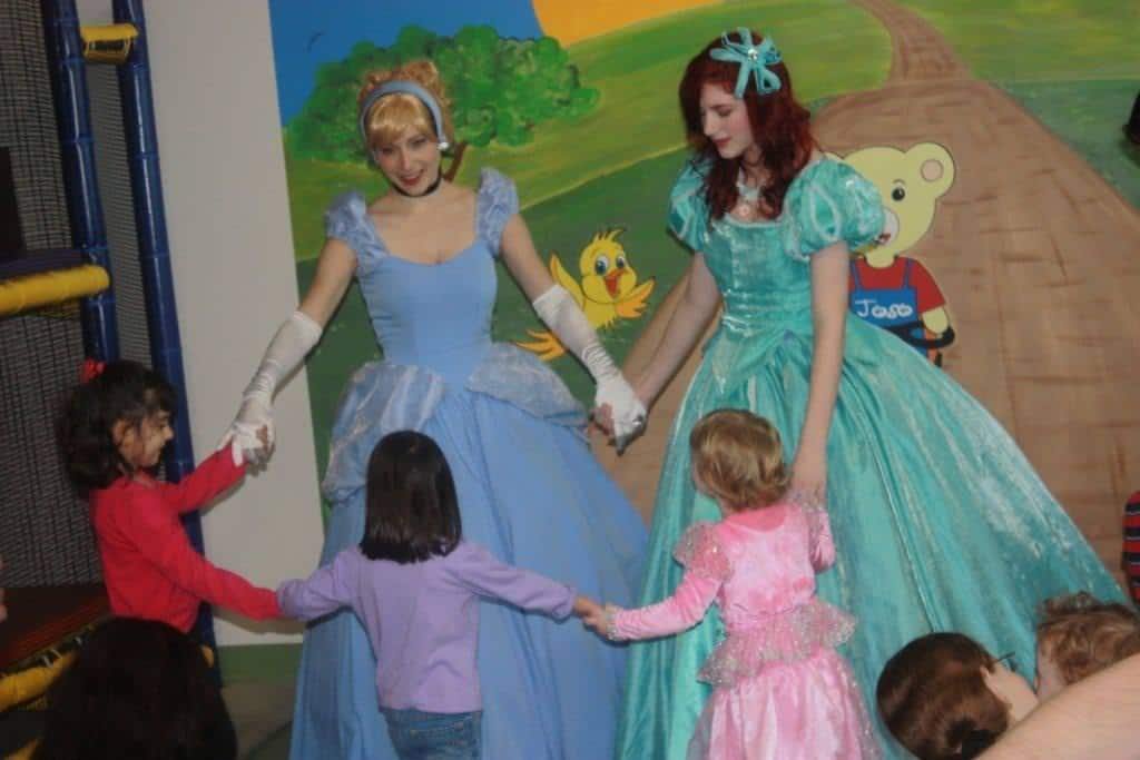 Princess Cinderella and Princess Little Mermaid dancing with little princesses