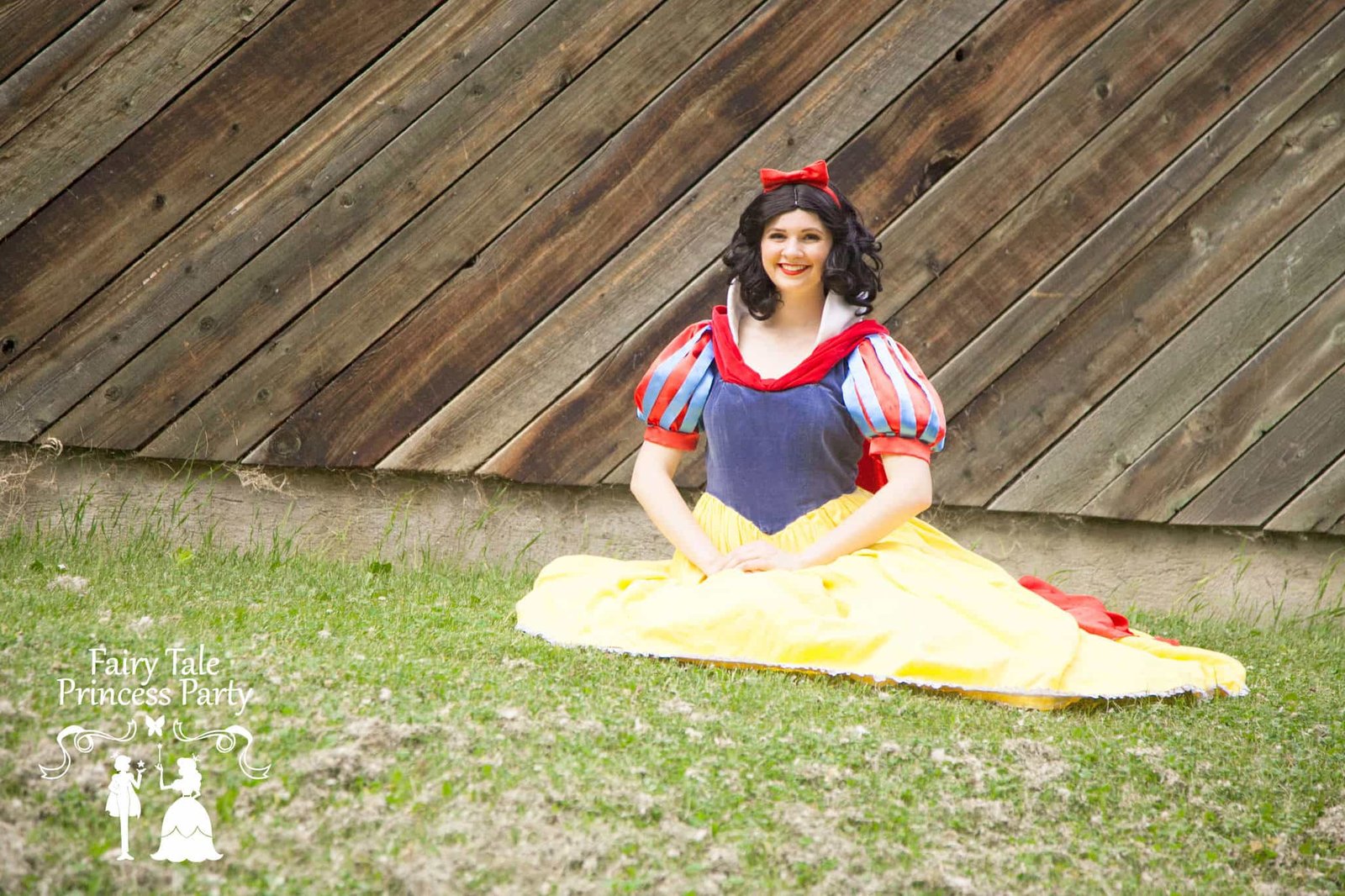 The Apple Princess sitting in Calgary grass at a picnic themed birthday party